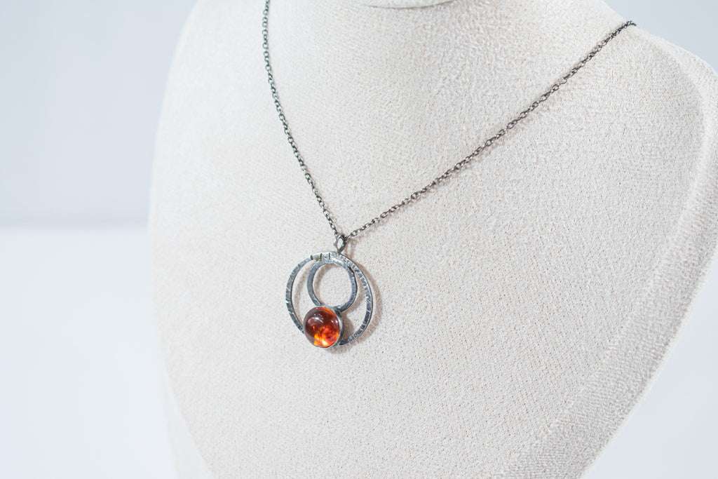 Elegant sterling silver hoop pendant featuring a unique natural amber stone, exuding charm and sophistication. A timeless piece perfect for everyday wear or special occasions