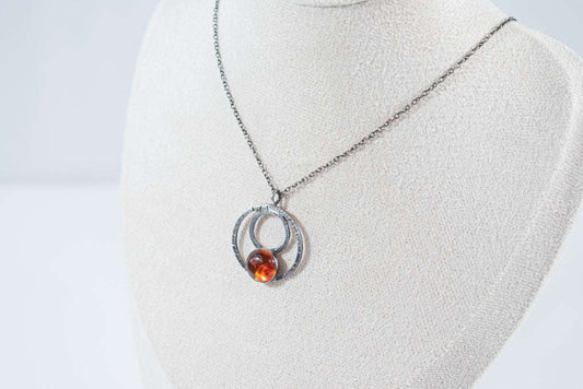 Elegant sterling silver hoop pendant featuring a unique natural amber stone, exuding charm and sophistication. A timeless piece perfect for everyday wear or special occasions