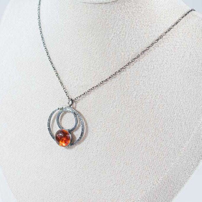 Elegant sterling silver hoop pendant featuring a unique natural amber stone, exuding charm and sophistication. A timeless piece perfect for everyday wear or special occasions