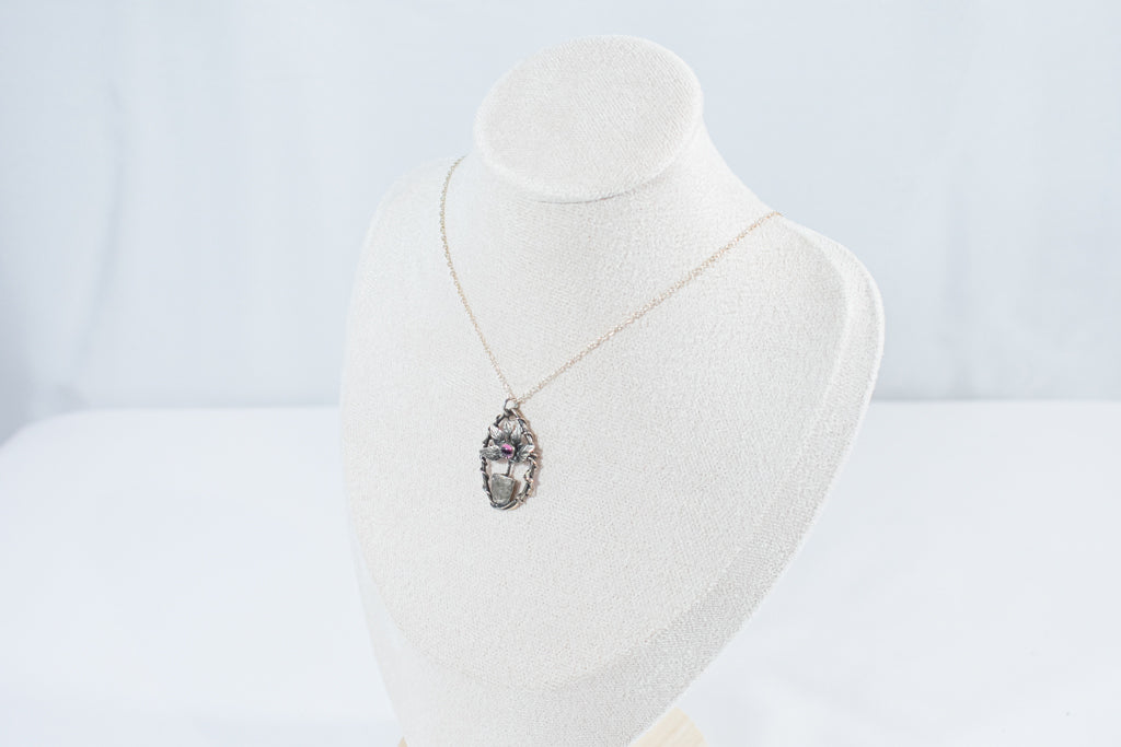 legant miniature leaf pendant necklace featuring a deep red garnet stone, crafted in sterling silver.