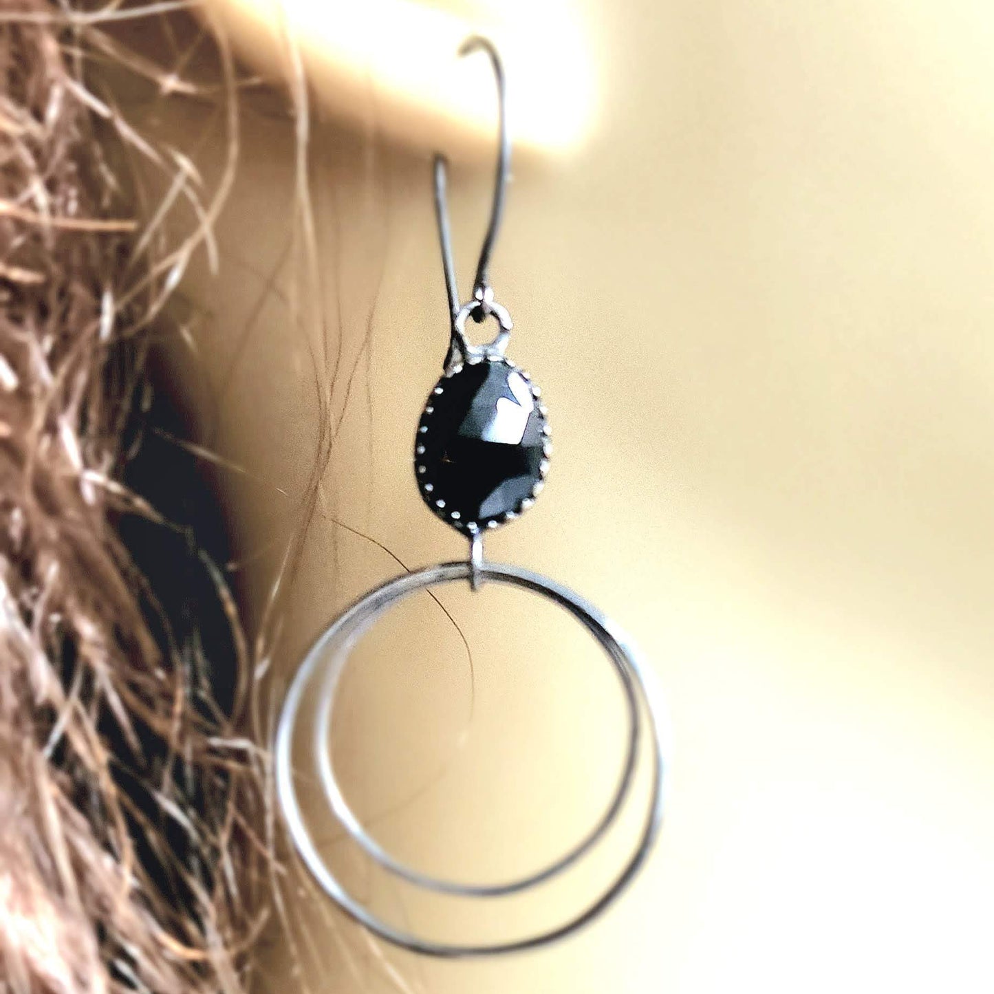 Handcrafted sterling silver hoop earrings adorned with captivating black Spinel stone drops, exuding elegance and charm.