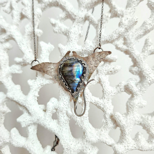 Labradorite pendant sculpted into the fluid form of a graceful manta ray, shimmering with iridescent hues. A striking statement piece symbolizing wisdom and effortless elegance.