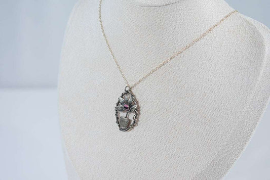 Elegant miniature leaf pendant necklace featuring a deep red garnet stone, crafted in sterling silver.