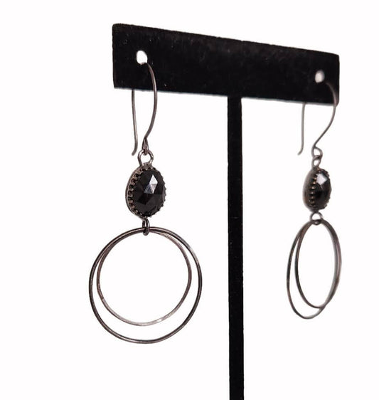 Handcrafted sterling silver hoop earrings adorned with captivating black Spinel stone drops, exuding elegance and charm.