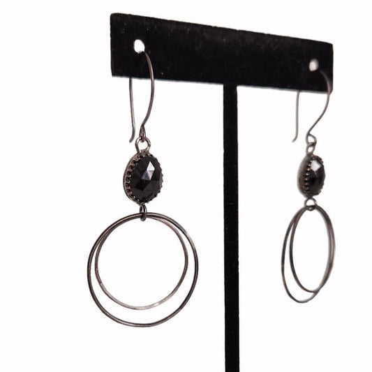 Handcrafted sterling silver hoop earrings adorned with captivating black Spinel stone drops, exuding elegance and charm.