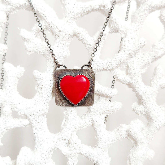 Heart-shaped pendant crafted from sterling silver and vibrant Rosarita Gold slag, featuring a radiant front and a back adorned with a delicate flower motif and the word 'LOVE.' A unique and timeless piece symbolizing warmth and affection.