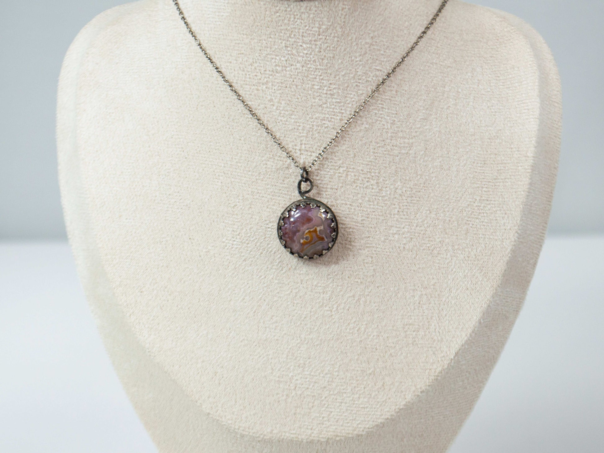 Elevate your style with this handcrafted Agua Nueva Agate pendant necklace. Set in a sterling silver bezel with an open back, this unique gemstone hangs from a delicate silver chain, showcasing nature’s artistry. Shop now for timeless elegance!