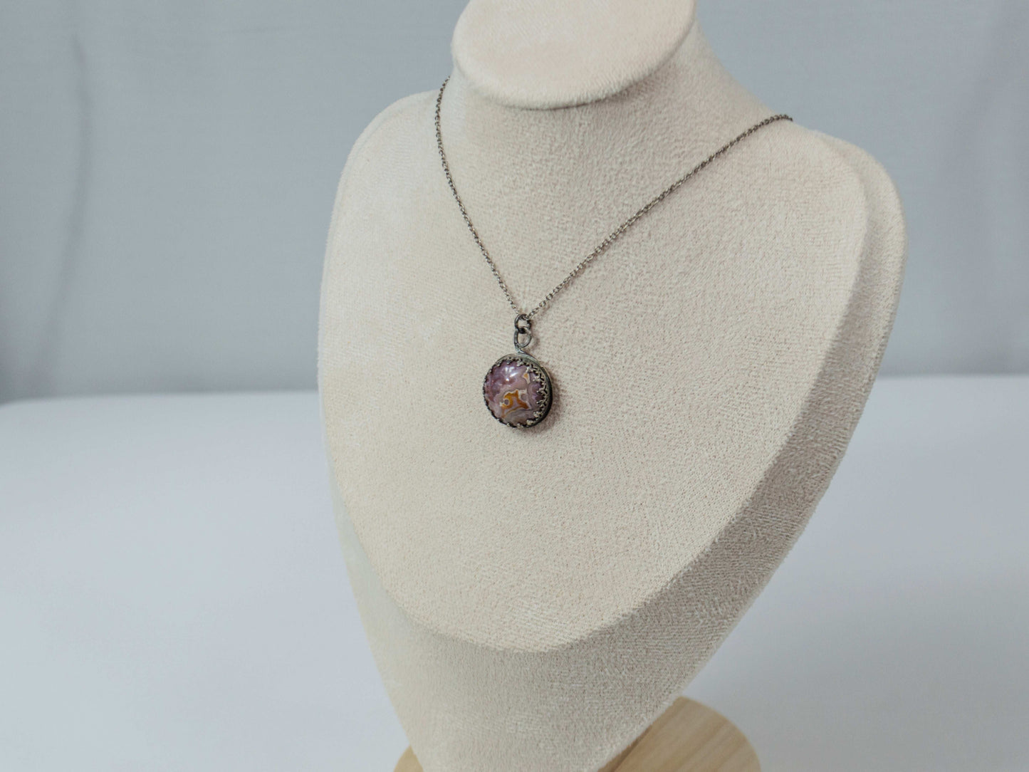 Elevate your style with this handcrafted Agua Nueva Agate pendant necklace. Set in a sterling silver bezel with an open back, this unique gemstone hangs from a delicate silver chain, showcasing nature’s artistry. Shop now for timeless elegance!