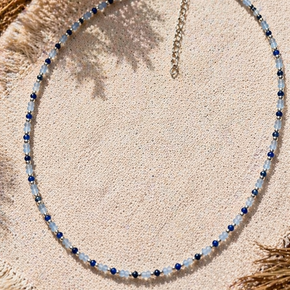 Beaded necklace on a textured surface with natural elements