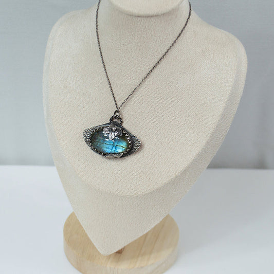 Necklace with a pendant on a mannequin bust against a plain background