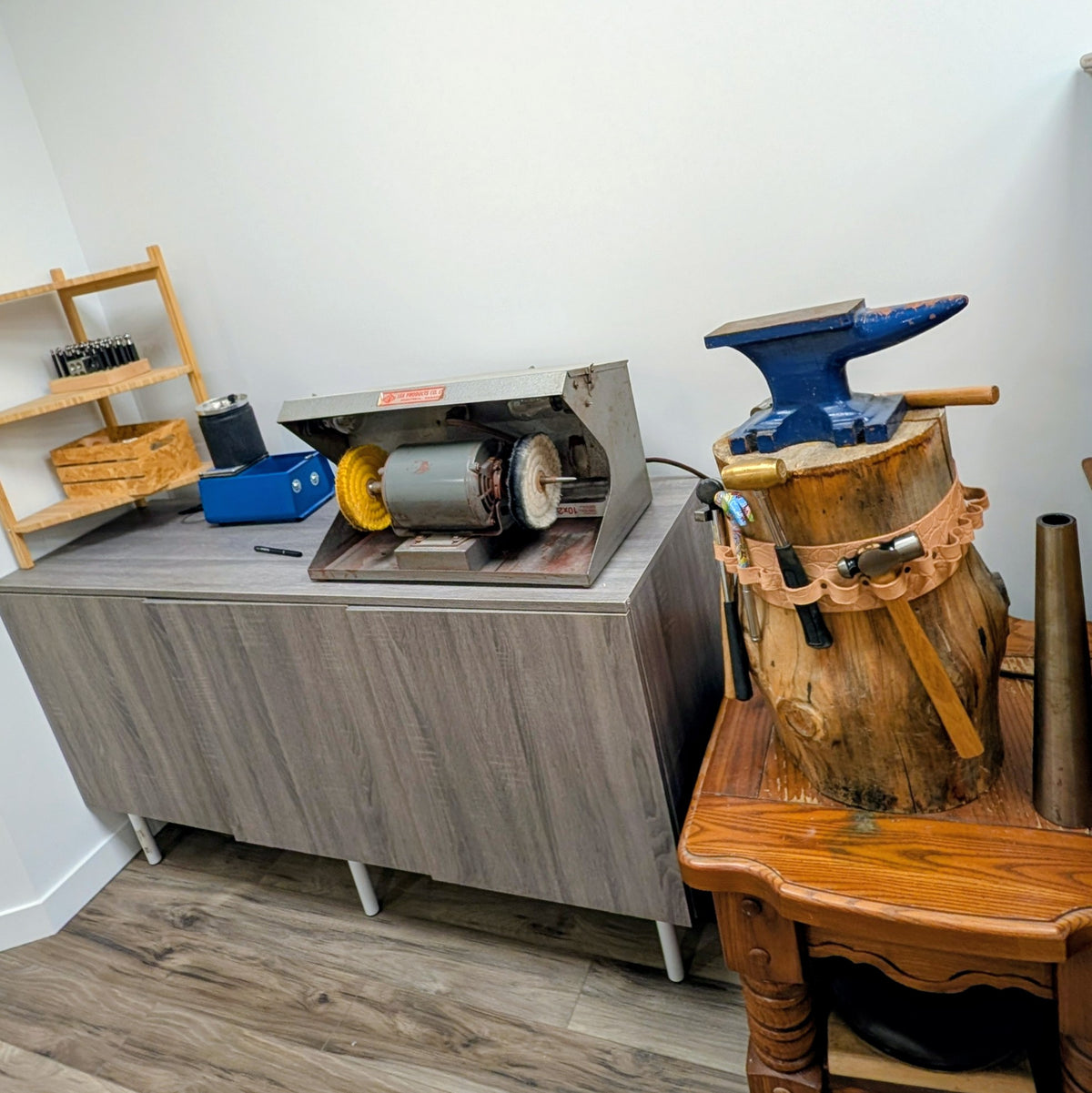 Workshop setup with a metal workbench and tools on a wooden floor.